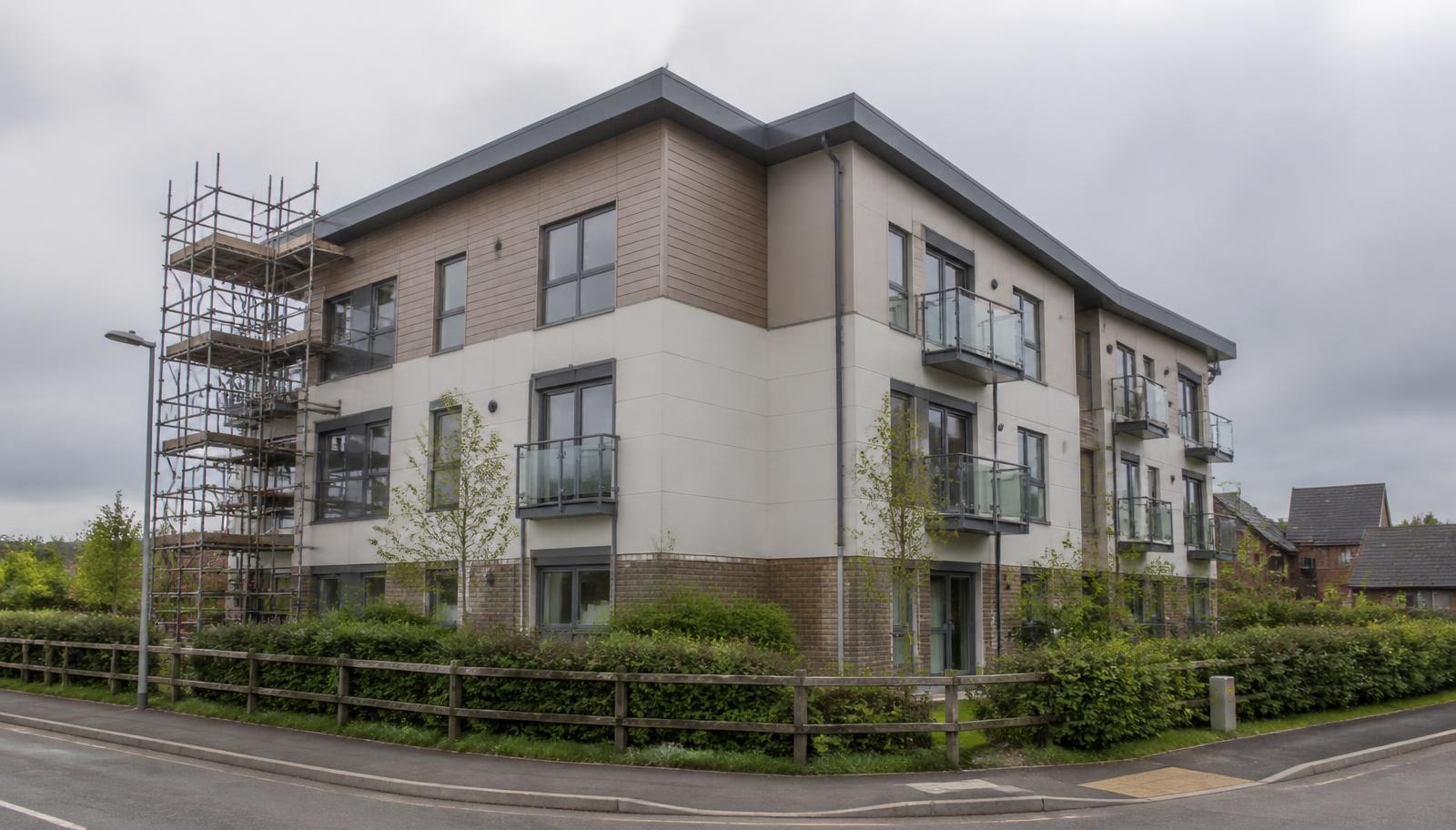 Low-rise residential apartment block under 11 metres with panel cladding and scaffolding to one elevation
